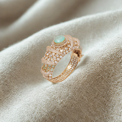 Luxurious gold bracelet with emerald and diamond accents exudes timeless sophistication and regal charm.