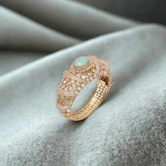 Luxurious gold bracelet with emerald and diamond accents exudes timeless sophistication and regal charm.