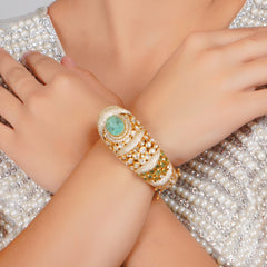 Luxurious gold bracelet with emerald and diamond accents exudes timeless sophistication and regal charm.