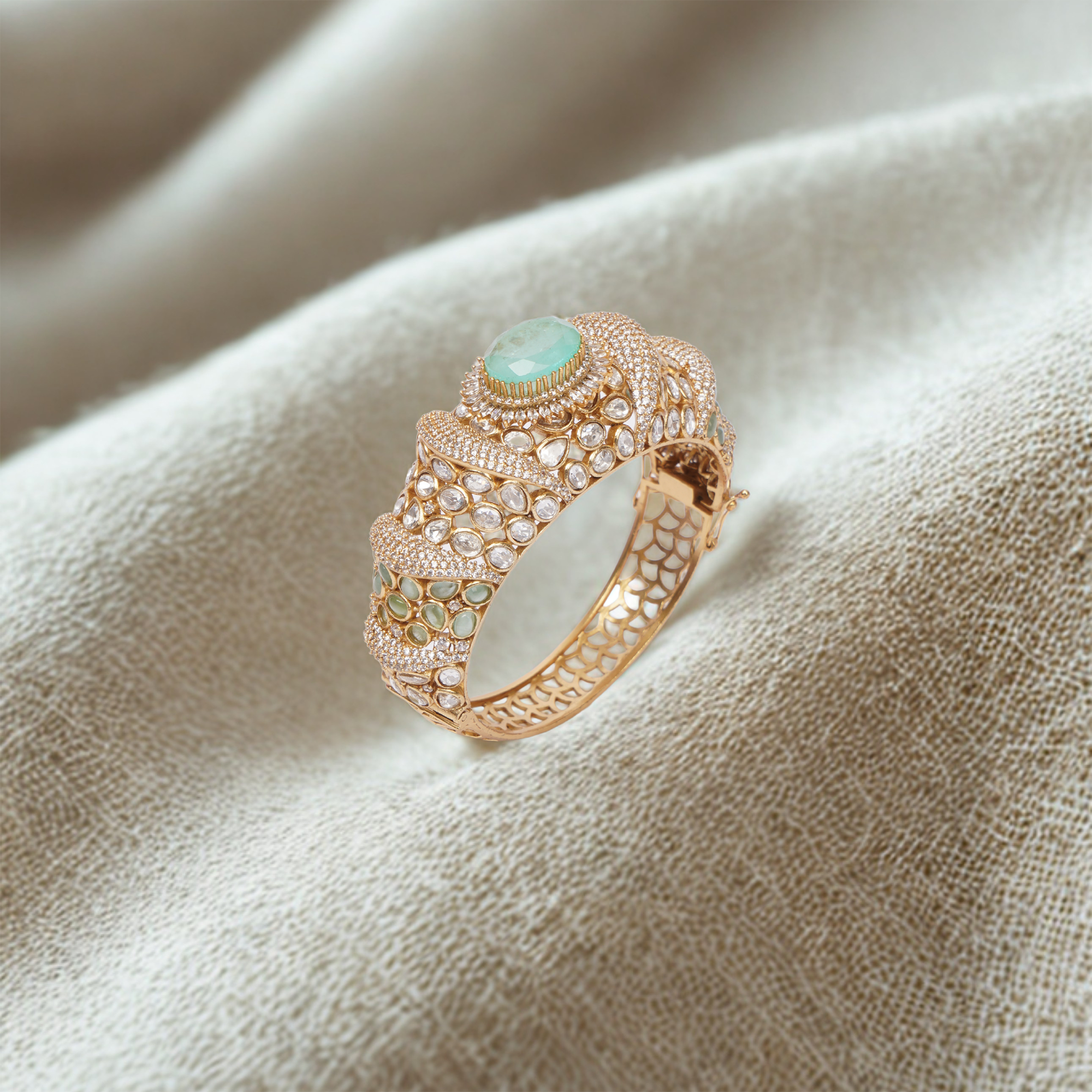 Luxurious gold bracelet with emerald and diamond accents exudes timeless sophistication and regal charm.