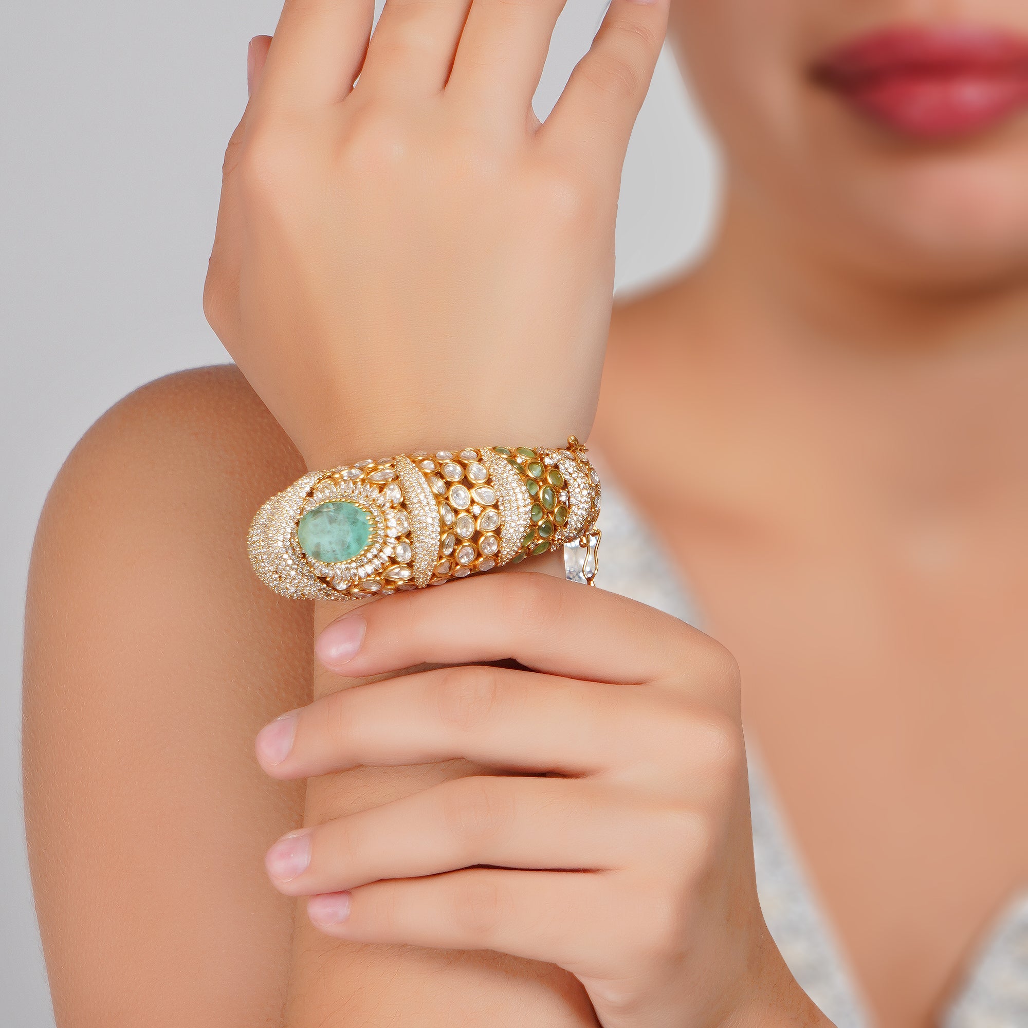 Luxurious gold bracelet with emerald and diamond accents exudes timeless sophistication and regal charm.